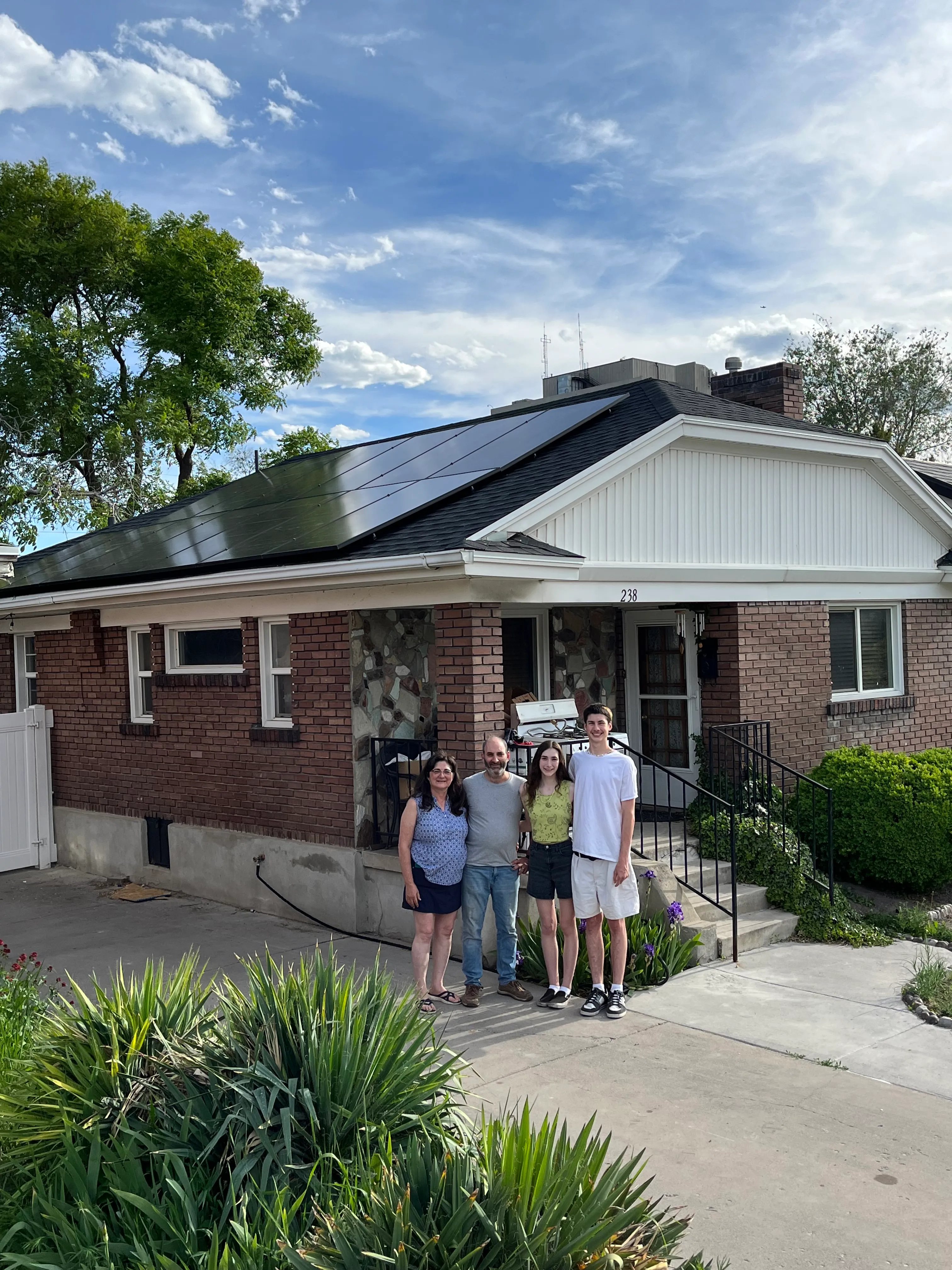 A Salt Lake City family standing in front of their home after solar panel installation